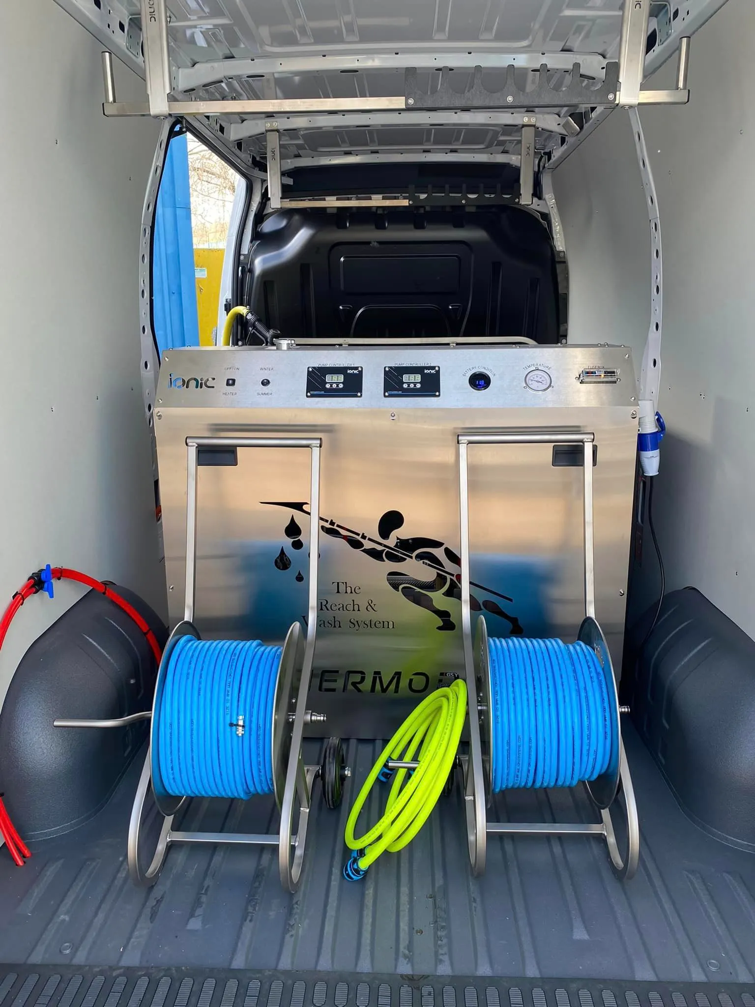 The back of a van with two hoses in the back.