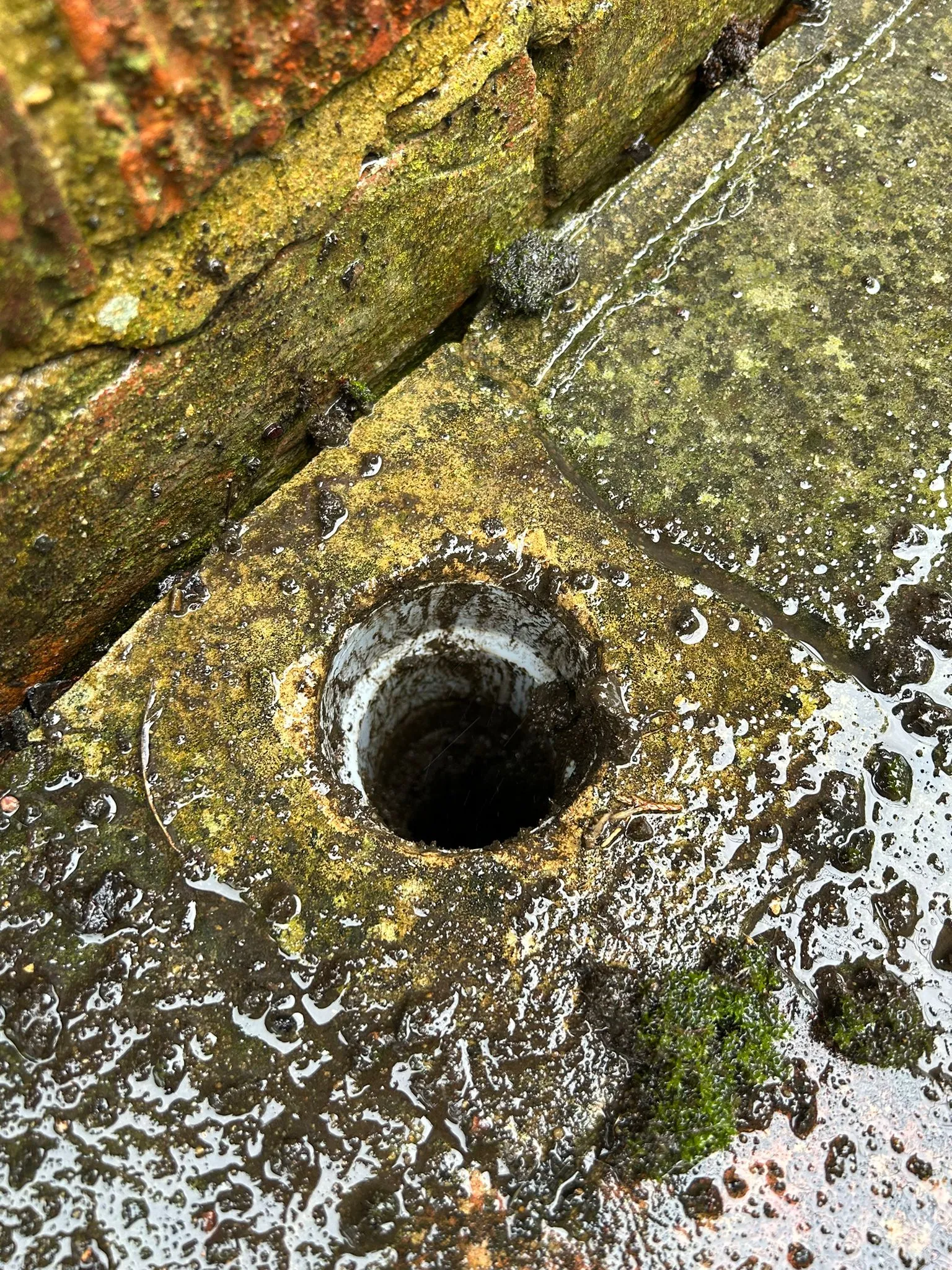 A hole in the ground with water coming out of it.