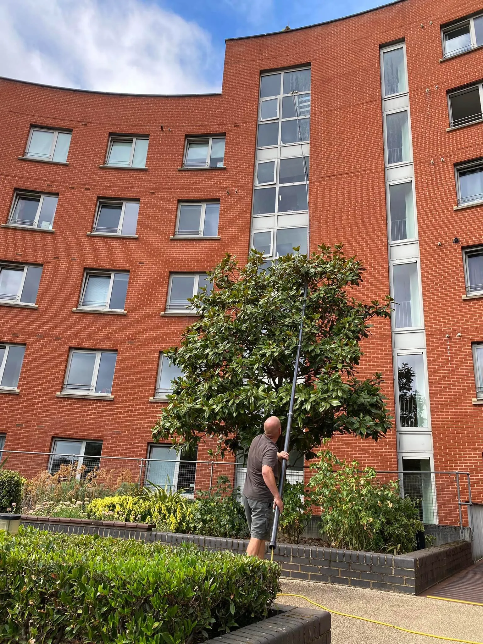 A man with a pole in front of a building.