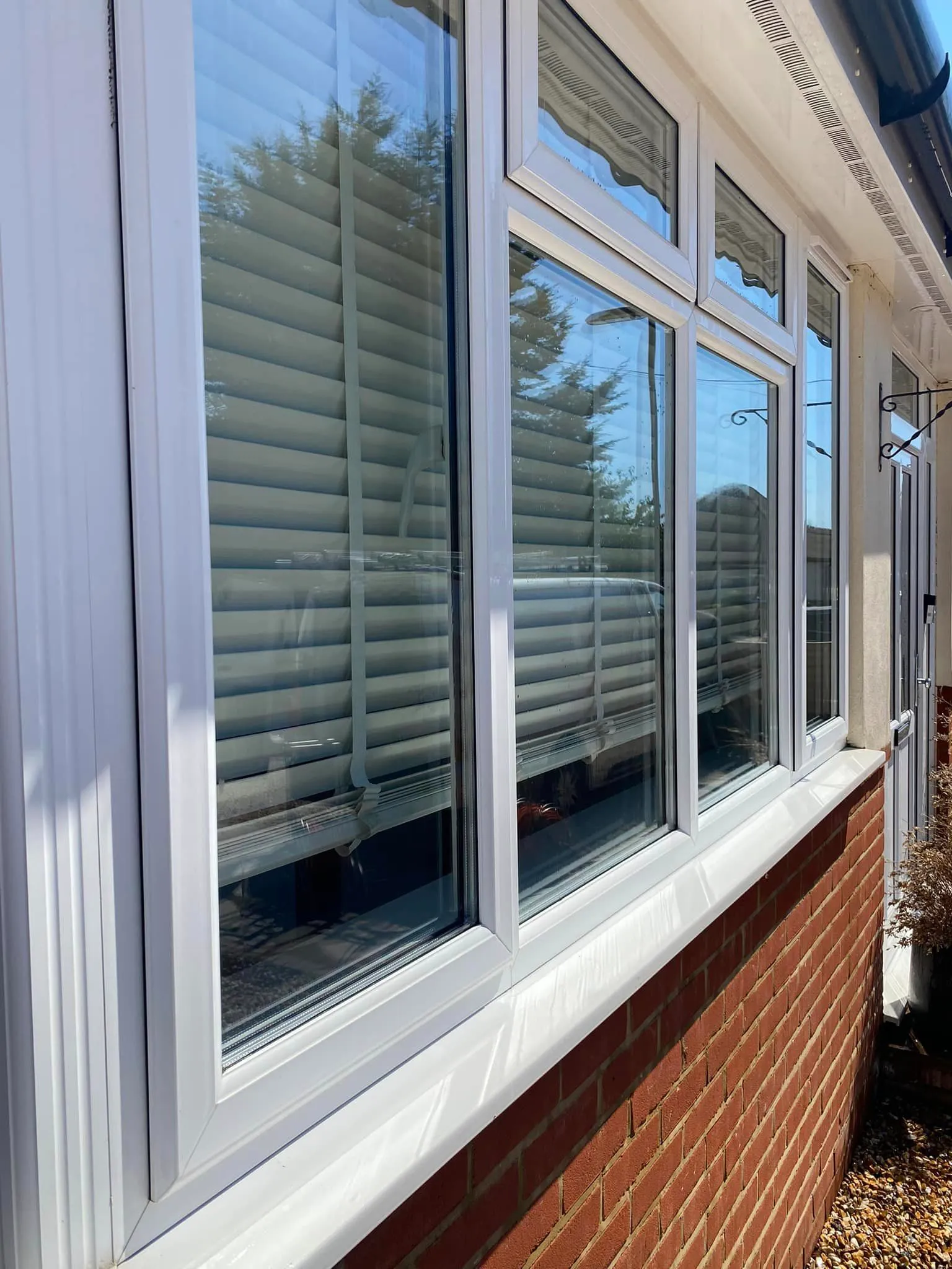 A brick building with a white window covering.